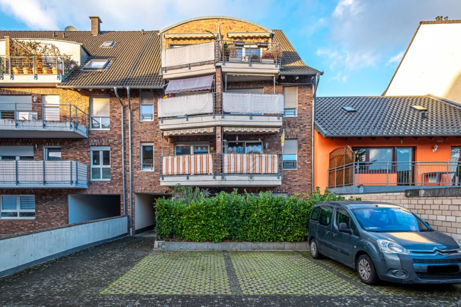 Hausrückseite mit Stellplatz (1. von links) - Wohnkomfort trifft auf perfekte Lage: 2 ZKB mit Balkon und Stellplatz in Frechen zu verkaufen!